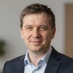 Профессиональный портрет уверенного бизнесмена компании Ральф Арт на нейтральном размытом фоне студии
